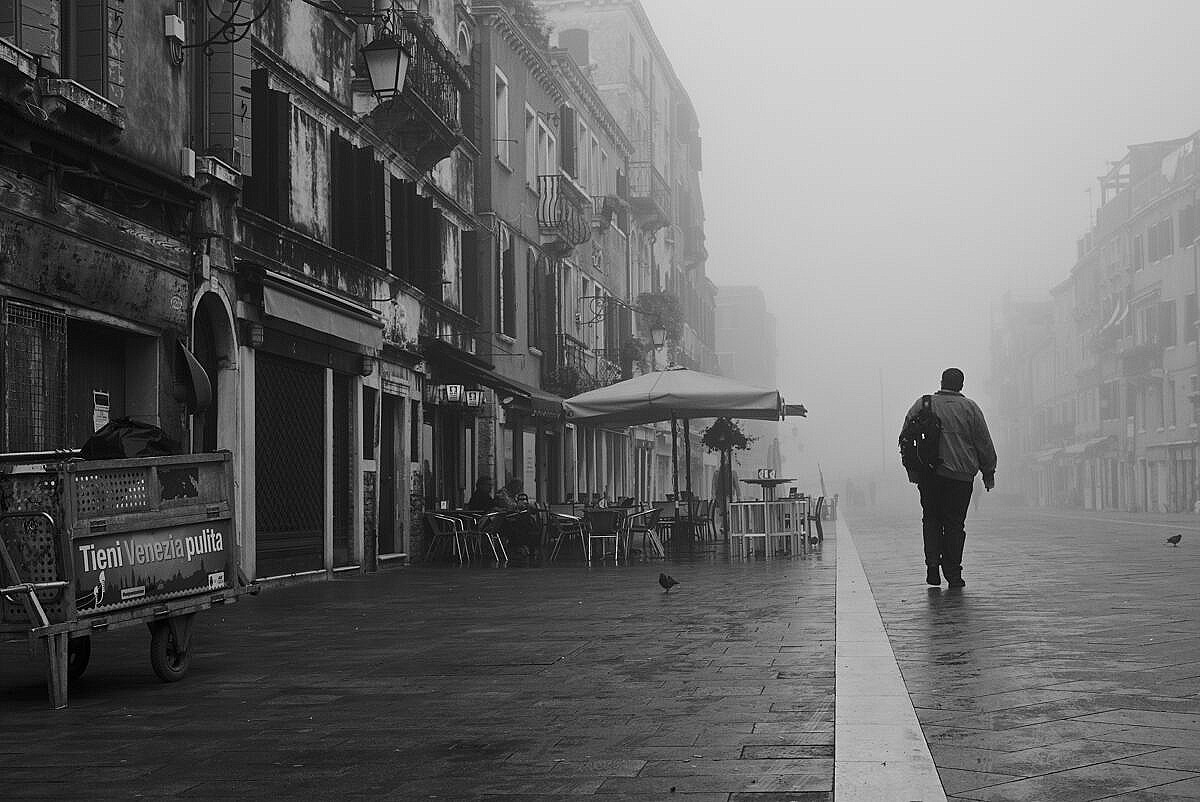 Man walking down the Via Garibaldi in Venice into the mist