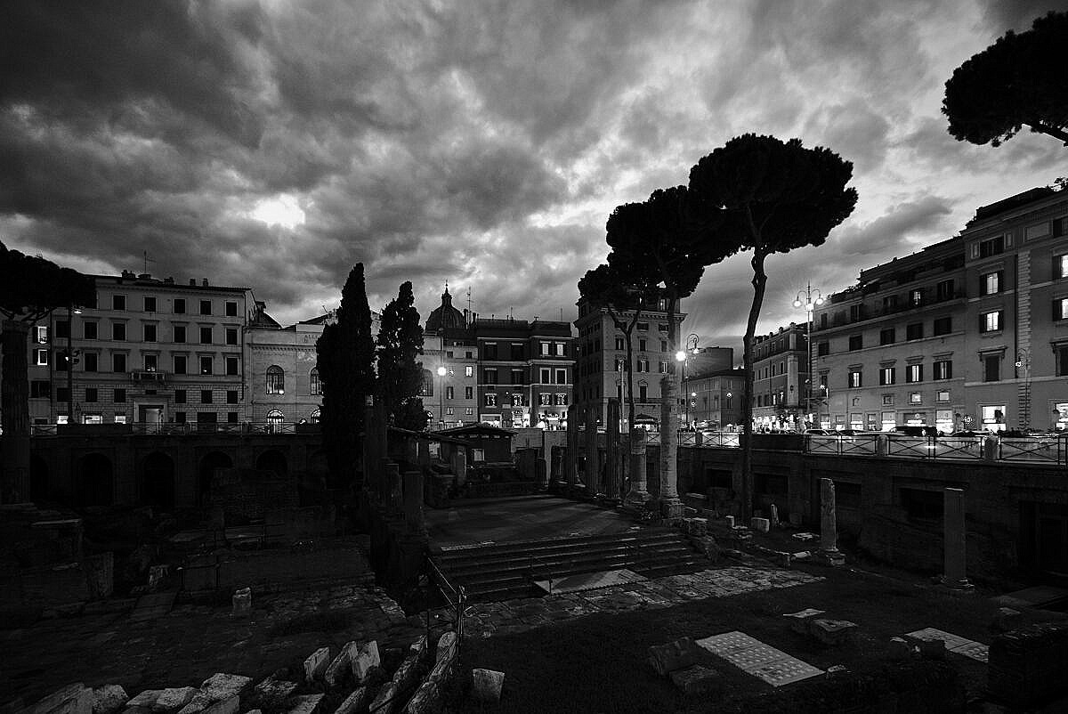 The Roman ruins of the Largo Argentina in Rome, after dark with a dramatic sky.