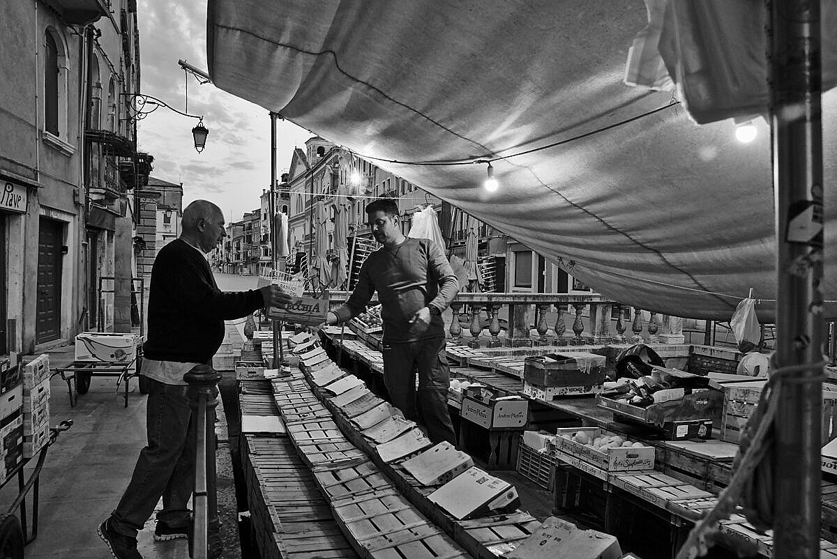The greengrocers on a boat in Via Garibaldi getting ready in the early morning.