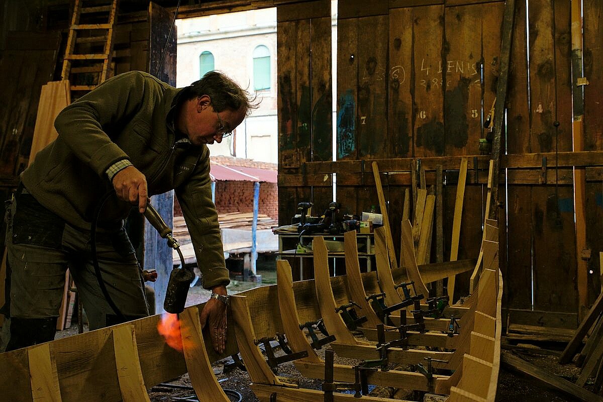 The flanks of a gondola are made of oak planks which have to be bend into shape using heat and water